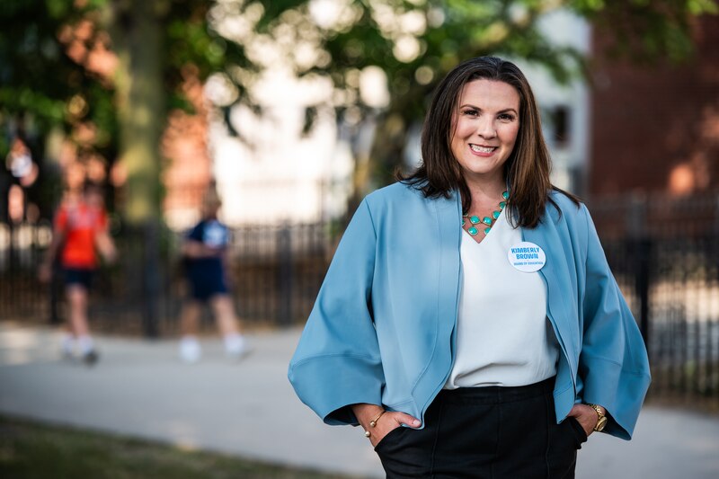 A woman in a light blue jacket and white top